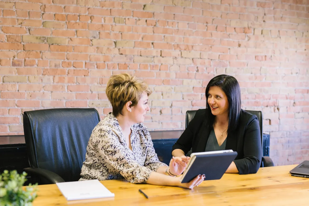 Two colleagues going over figures together at a desk